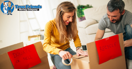 Couple putting labels on moving boxes